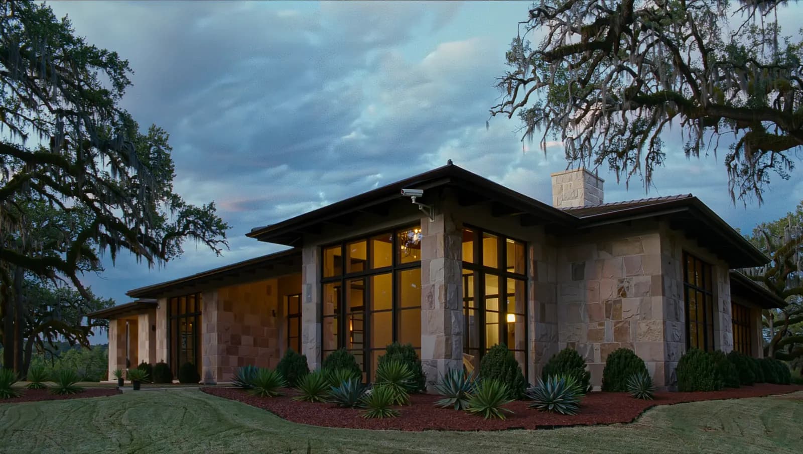 Limestone Hill Country home at dusk with a security camera under the eave