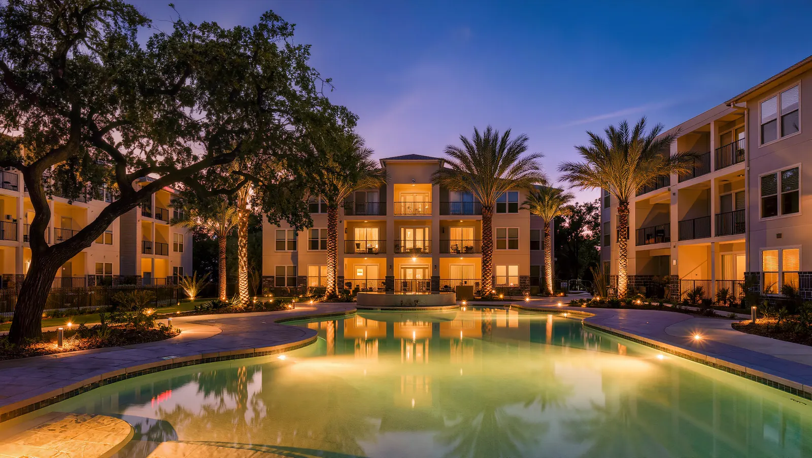 Apartment community courtyard and pool at twilight